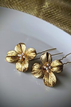 Beautiful bridal gold flower Hair Pins - a set of 2 hair pins - all lovingly hand made using gold gilted polymer clay flowers withivoty white Czech glass pearls for the centre.  They come in a set of 2 and would look perfect in a loose bun, soft updo or plait. To see the same hair pins style with WHITE PEARL colour Flowers instead, please follow the link below: https://www.etsy.com/uk/listing/1640647494/bridal-hair-pins-set-of-2-wedding-pearl THIS ITEM IS MADE TO ORDER (1-2 weeks) SO PLEASE BE PATIENT. Matching Items HAIR ACCESSORIES: https://www.etsy.com/uk/listing/1520466391/bridal-headpiece-boho-bridal-tiara EARRINGS: https://www.etsy.com/uk/listing/870423674/moonstone-earrings-pink-swarovski https://www.etsy.com/uk/listing/1114968515/wedding-gold-fan-rhinestones-earrings https://www.et Gold Flower Hair Pin, Gold Hair Pins, Loose Bun, Boho Bridal Headpiece, Soft Updo, Gold Bracelet Wedding, Hair Pins Bridal, Colour Flowers, Flower Hair Pins