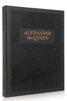 a black book with gold lettering that reads,'the life and times of alexander mcqueen