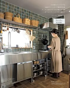 a woman standing in a kitchen next to a sink and oven with pots on the wall