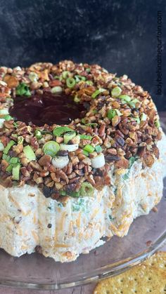 a cake with nuts and other toppings sitting on top of a glass platter