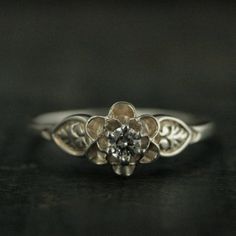 This sweet little floral ring is named after my childhood best friend's baby sister, Julie. She would tag along on our trips through the woods looking for wildflowers and join us in our creek side adventures. This ring is the embodiment of our innocent childhoods looking for the first spring flowers.Featuring a six prong setting that holds a 3mm stone of your choice, it is surrounded by silver petals. The flower spans 7mm in diameter and is accentuated by two stylistic leaves (one on each side). Nature Promise Rings, Adjustable Delicate Flower Promise Ring, Delicate Wedding Flower Ring With Charm, Delicate Wedding Flower Ring With Flower Charm, Vintage Promise Rings Silver, Delicate Flower Shaped Promise Ring, Nickel-free Flower Ring For Anniversary, Delicate Promise Ring With Flower Shape, Dainty Flower Ring With Charm For Promise