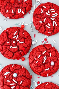 red velvet cookies with sprinkles and white frosting on a table top