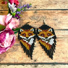 the beaded earrings are next to pink flowers