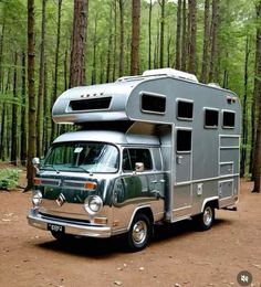 an rv parked in the middle of a forest