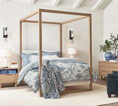 a four poster bed with blue and white comforter