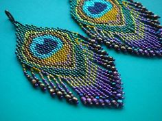 two pairs of beaded earrings with peacocks on them