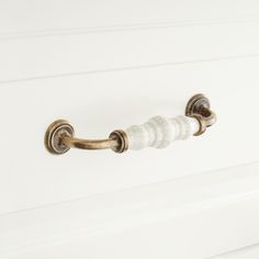 a white door handle with marble accents on it's side and the handles are gold