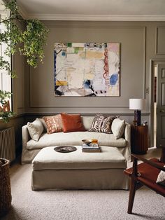 a living room filled with furniture and a painting on the wall