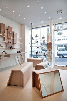 the inside of a shoe store with lots of shelves and chairs in front of it