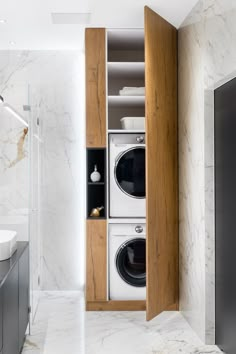 a washer and dryer in a bathroom with marble walls