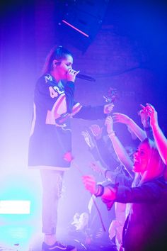 a group of people standing on top of a stage with microphones in their hands