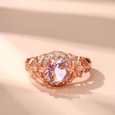 This exquisite piece showcases a captivating combination of elegance and femininity. Crafted in sterling silver, this beautiful ring showcases a sparkling round-cut morganite stone radiating a soft and romantic glow and flower detailing along the ring's shank lending heirloom appeal to this elegant design. Delicate and romantic, this ring is the perfect choice for her.Carat Weight: 1.28 ctStone Size: 7 mmStone Type: Jeulia® StoneNumber of Stones: 1 Stone Shape: RoundStone Color: Fancy PinkCarat Weight: 0.394 ctStone Size: 1,1.3,1.4,1.6,1.8 mmStone Type: Jeulia® StoneNumber of Stones: 16 Stone Shape: RoundStone Color: Diamond WhiteWeight: 4.5 gWidth: 1.1 mmHeight: 7.4 mmThickness: 2.8 mmMaterial: 925 SilverPlating Color: Rose Gold Elegant Morganite Solitaire Diamond Ring, Rose Gold Flower Ring With Center Stone For Promise, Elegant Rose Gold Cubic Zirconia Flower Ring, Elegant Morganite Solitaire Rings, Elegant Solitaire Morganite Rings, Elegant Morganite Wedding Ring With Brilliant Cut, Elegant Pink Gold Jewelry With Center Stone, Exquisite Morganite Rose Gold Rings, Fine Jewelry Morganite Diamond Ring In Rose Gold