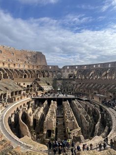 the interior of an ancient roman colossion with people standing around it and looking at the ground