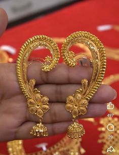 a person is holding some gold jewelry in their hand