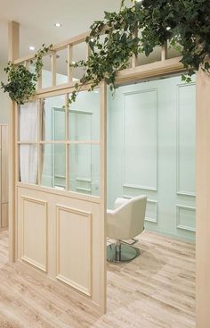 an open door leading into a room with green plants on the wall and wooden floors