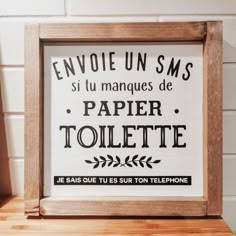 a wooden frame with the words envoie un sms, si tu manquees de papier toilette