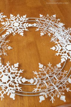 snowflakes are arranged on a table to make a wreath for the holiday season