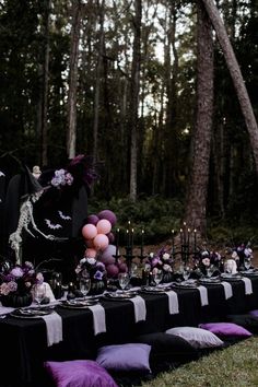 a long table is set up with purple and black decorations