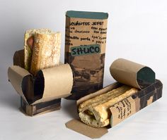 an assortment of food items displayed on white surface with box and paper wrapper in foreground