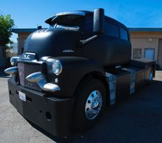 a black semi truck parked in a parking lot