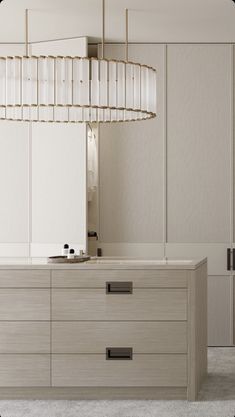 a modern kitchen with white cabinets and an oval light fixture hanging over the countertop