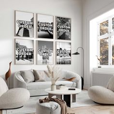 a living room filled with white furniture and posters on the wall above it's windows