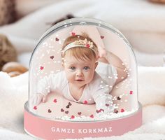 a baby girl in a glass dome with hearts on it's head and hands