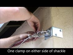 a man working on a wall with a pair of pliers attached to the side of it