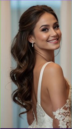 a beautiful young woman with long hair wearing a white dress and smiling at the camera