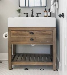 a bathroom with a sink, mirror and towel rack on the wall next to it