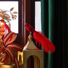 a red bird sitting on top of a christmas tree