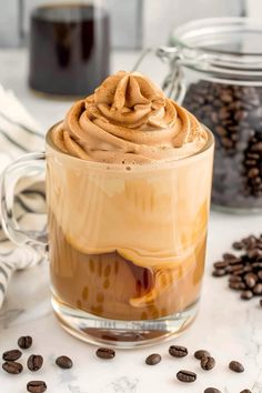 a glass mug filled with coffee and topped with whipped cream