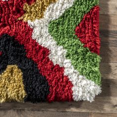 a multicolored area rug on top of a wooden floor next to a pair of scissors