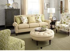 a living room filled with lots of furniture and pillows on top of a green rug