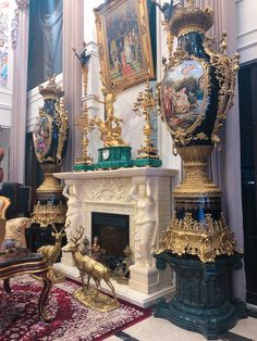 an ornate fireplace in the middle of a room with paintings on the walls and floor