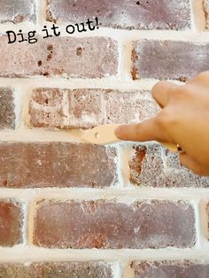 a person is pointing to a brick wall with the words dig it out on it