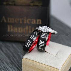 two wedding rings with the words ride or die on them sitting on top of an open book