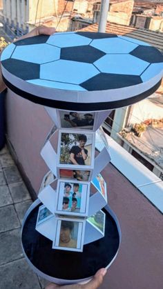 a person holding up a table with pictures on it and an upside down soccer ball