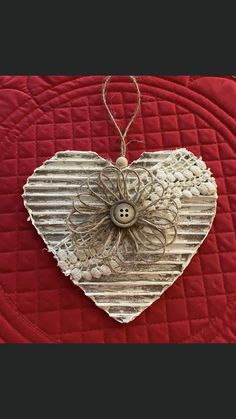 a heart shaped decoration hanging on a red quilt