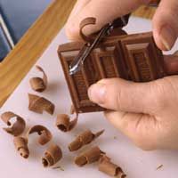 someone is cutting chocolate with a pair of scissors