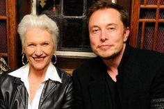 an older man and woman sitting next to each other in front of a wooden window