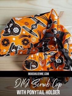 an orange bandana with black and white skulls on it, sitting on top of a wooden