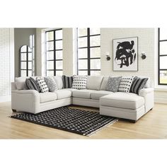 a living room with white couches and black and white pillows on the rugs