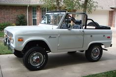 an old white truck parked in front of a house