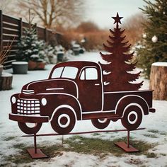 an old truck with a christmas tree on the back sits in front of a snowy yard