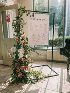 an arrangement of flowers sits in front of a piano