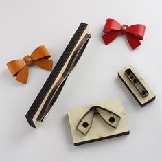 four pieces of wood with bows on them and two clips attached to the top one