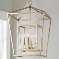 a chandelier hanging from the ceiling in a room with white walls and windows