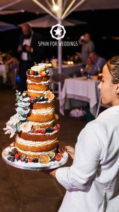 a woman is holding a wedding cake in her hand