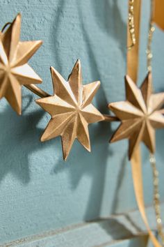 three gold stars hanging on a blue wall